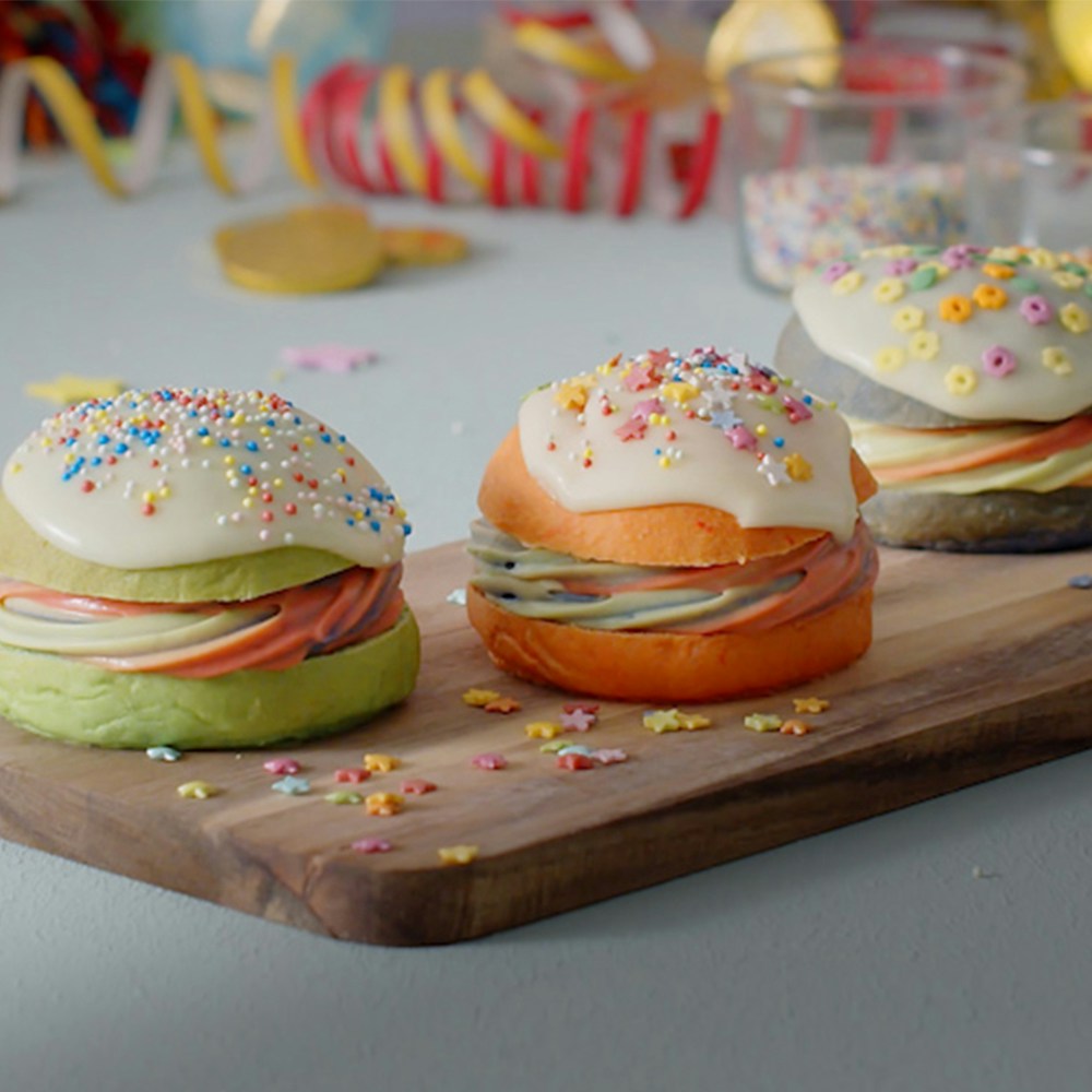 Grønne og orange fastelavnsboller med hvid glasur og tivolikrymmel.