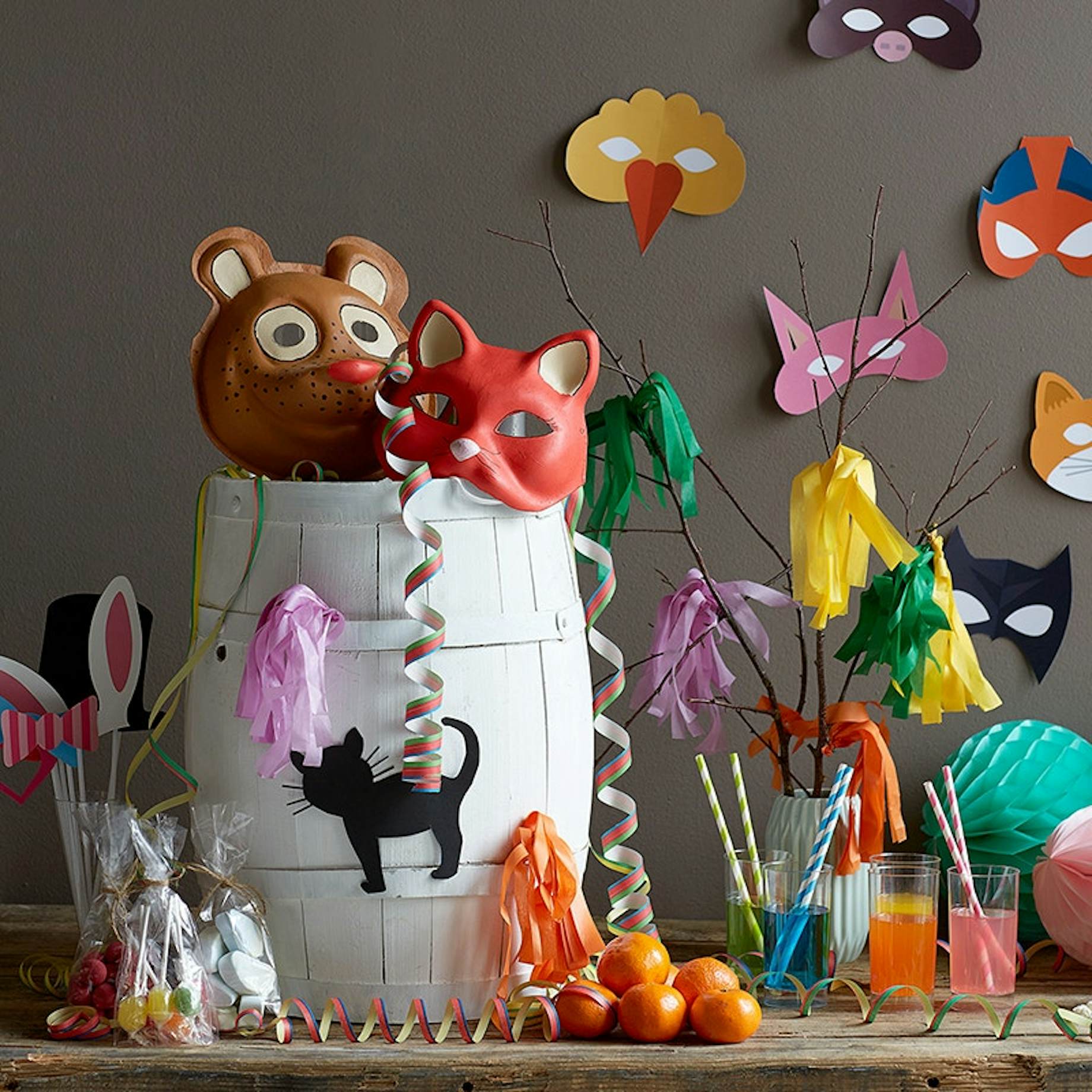 Fastelavnspynt med fastelavnstønde, masker, drinks og serpentiner.