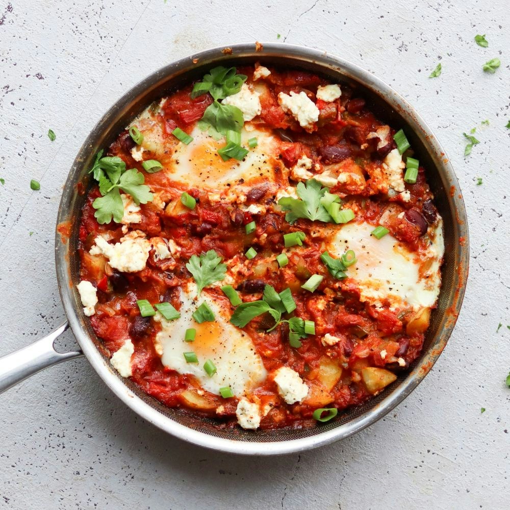 Shakshuka med grøntsager, æg, feta og urter