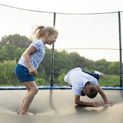 Børn hopper på udendørs trampolin