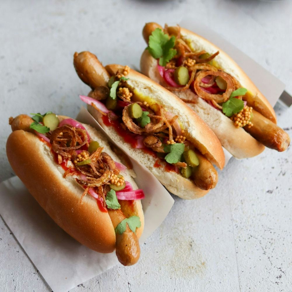 Hotdogs med syltede rødløg, ristede løg og sennepsfrø
