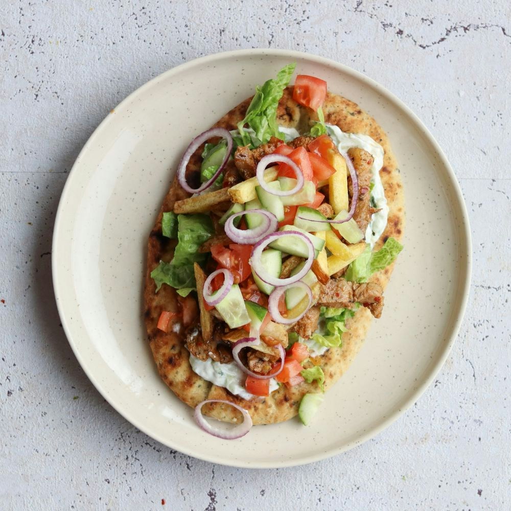 Græsk gyros med svinekød, grønt, pommes fritter og tzatziki